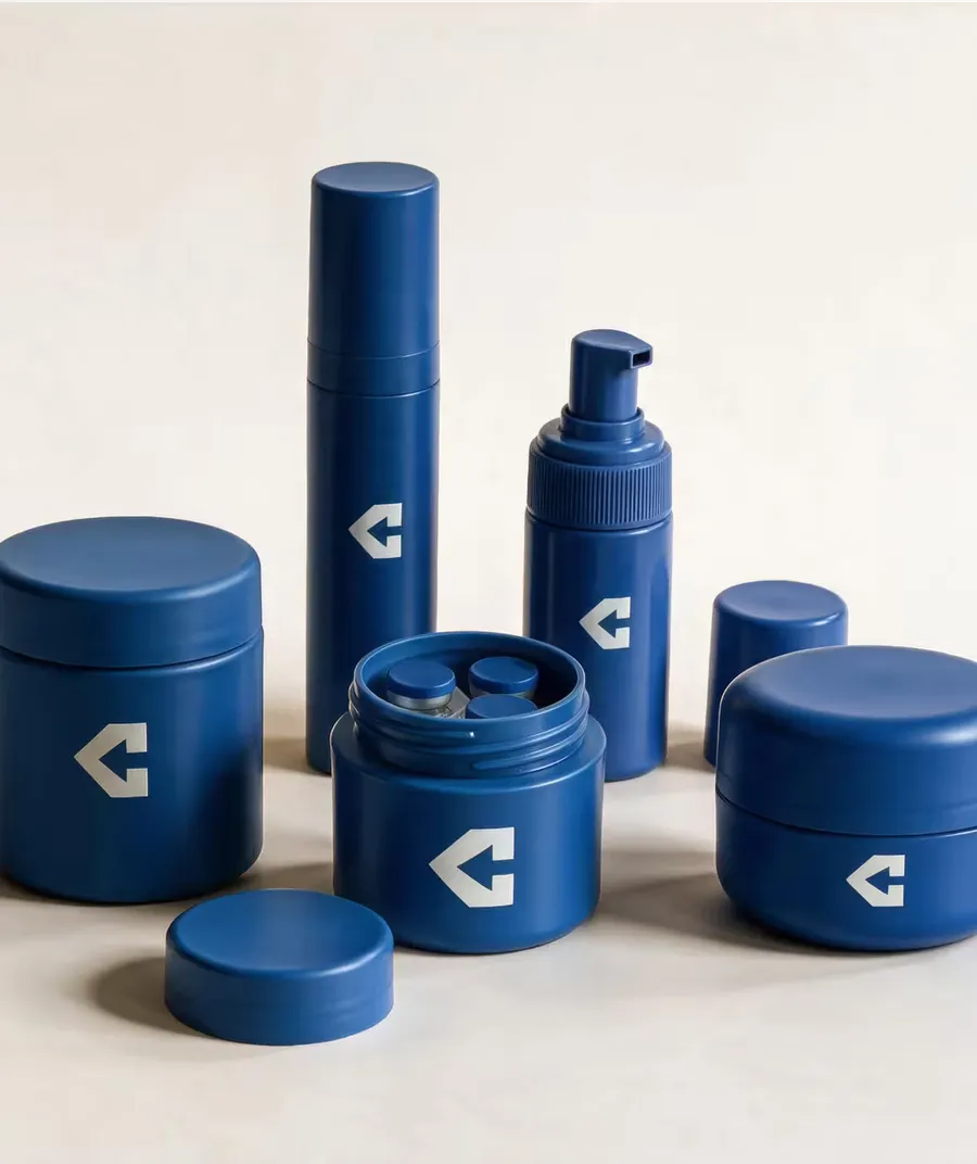 Navy CentiPack jars, a spray bottle and a pump dispenser grouped together, one jar open.