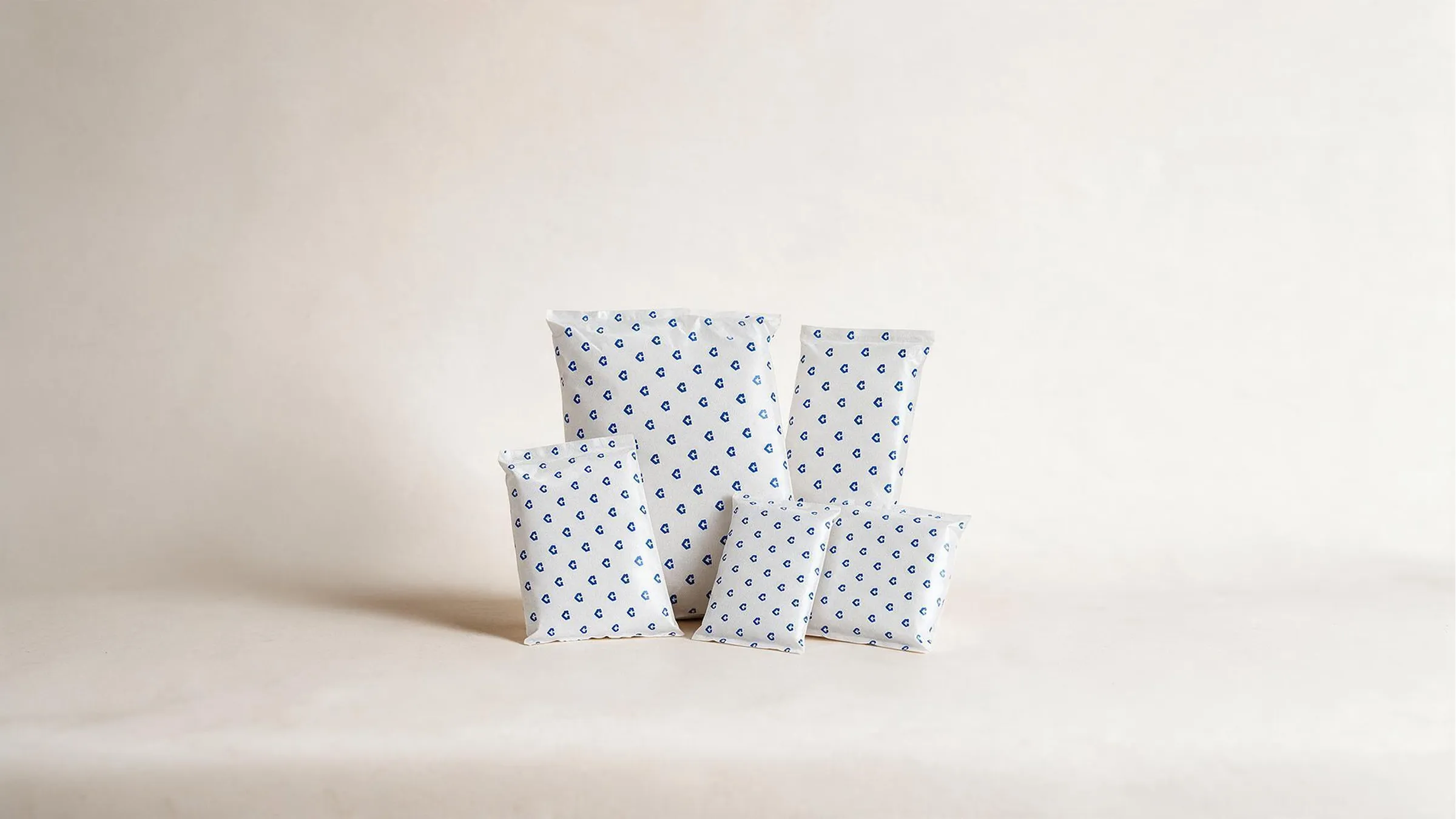Five CentiPack gel packs grouped on a cream ground in a range of sizes, each printed with a repeating pattern of small blue CentiPack arrows.